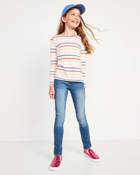 A girl model is wearing a striped fleece, a hat and a skinny jeans.