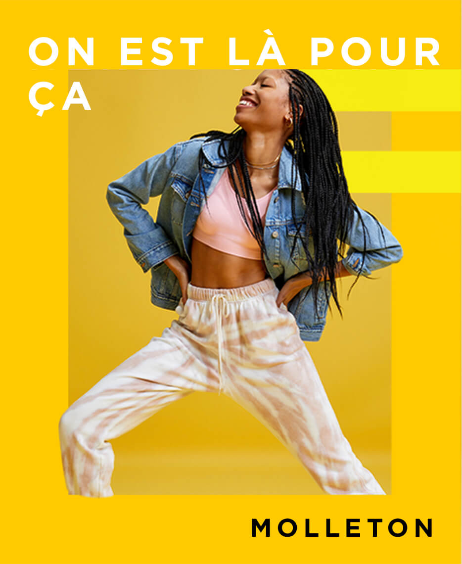 Une mannequin qui porte des pantalons en molleton avec une camisole et une veste en denim.