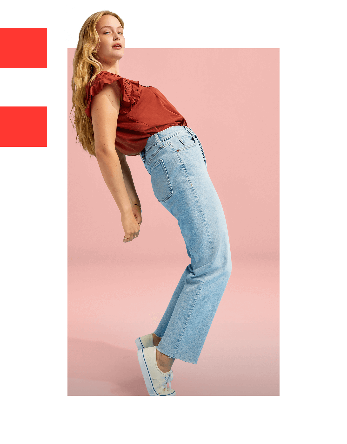 Une mannequin qui porte un jean droit au fini pâle et une blouse orange.