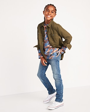 A young model wearing army green jacket, camouflage shirt and a skinny jeans.