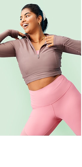A female model wearing an off-white high-neck half-zip sherpa sweater and activewear pants