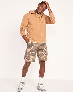 A male model wears a cream colored pull-over hoodie & Pull-On Cargo Shorts.
