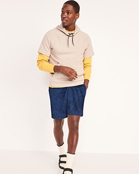 A male model wears contrasting activewear pull-over tops & dark blue Dynamic Fleece shorts.