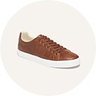 A pair of brown faux leather sneakers with white trim.