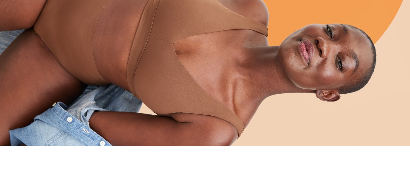 Une femme porte un soutien-gorge t-shirt et une culotte de couleur chair.