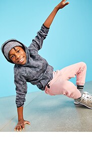 A young model is wearing dark color hoodie and pink sweatpants.