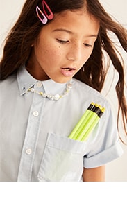 A young girl model wearing short sleeve white uniform shirt.