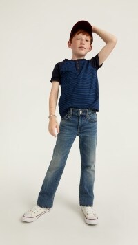 A male model wears Boot-Cut style jeans with a blue t-shirt.