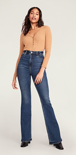 Model in dark faded flare jeans.