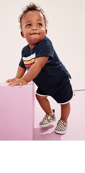 Un bébé porte un t-shirt unisexe à manches courtes et un short en jersey bouclette.