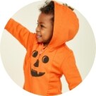 A baby wearing a hooded Halloween themed onesie.