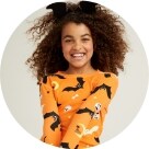  A young model dressed a Halloween patterened top.