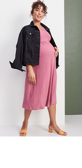 A maternity model wears a light pinkFit & Flare Long-Sleeve Rib-Knit Midi Dress & a dark denim jacket.