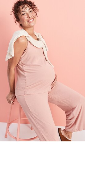 Une femme porte une camisole d’allaitement ultra-douce Sunday Sleep rose pâle et un pantalon de jogging ultra-doux assorti à taille rabattable Sunday Sleep de Maternité.
