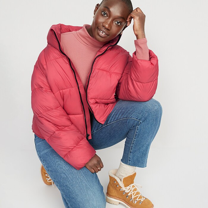 A female model wearing Old Navy New Arrivals styles including turtleneck, red puffer coat and jeans.