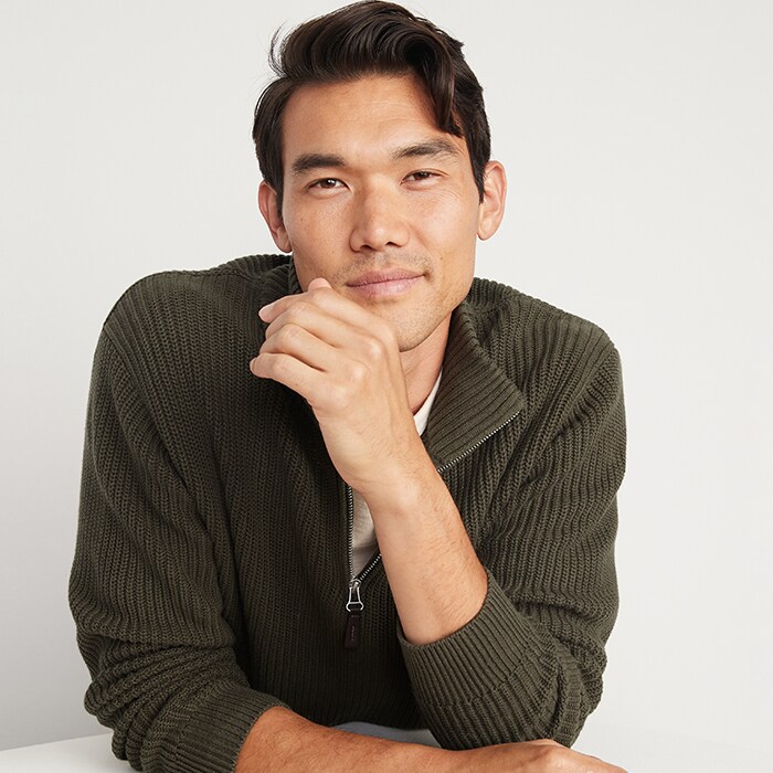 A male model wears Old Navy sale items including a olive green quarter-zip sweater.