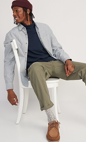 A male model wears green pants with a blue top.