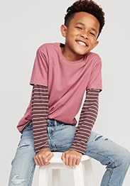 A young model wearing striped long sleeve shirt and over it a solid crew neck t-shirt and ripped jean.