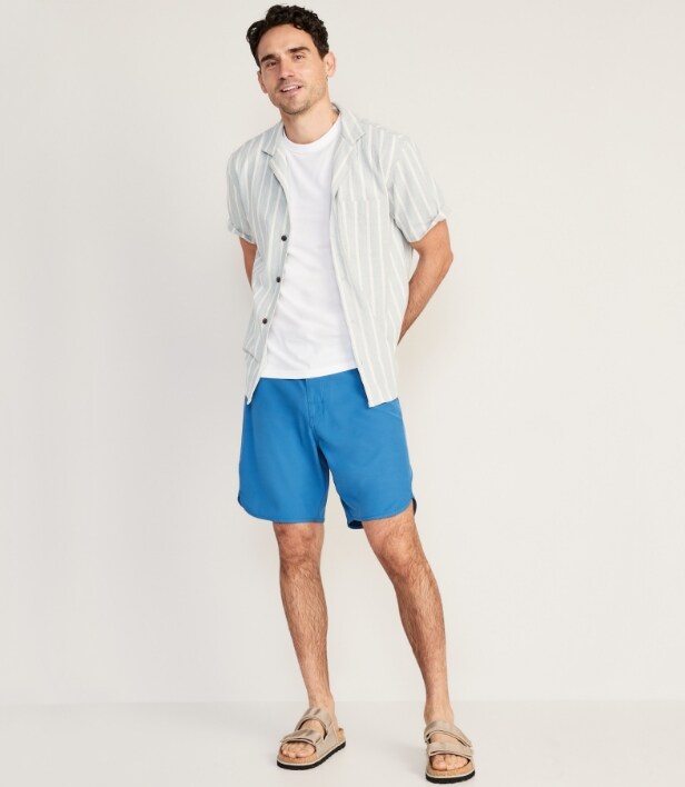 A model wearing solid swim 8" board short and a shirt.