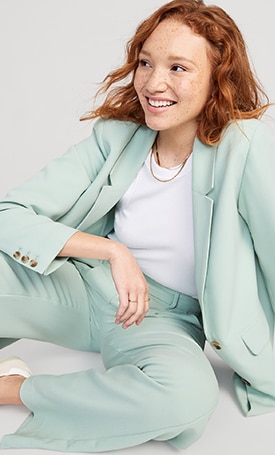 A female model wearing a light green pair of Extra High-Waisted Pleated Taylor Wide-Leg Trouser Suit Pants & matching blazer