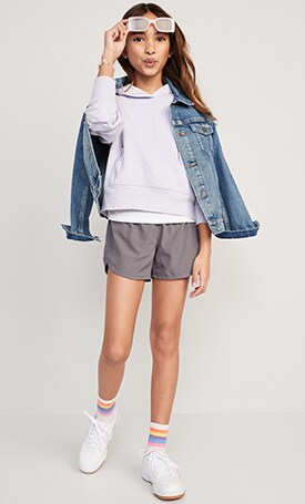 A young model wearing  solid hoodie, dolphin hem run short and jean jacket.