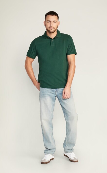 A male model wears Loose style jeans & a dark green polo shirt