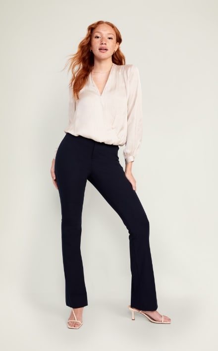 A female model wearing dark colored flare style pants